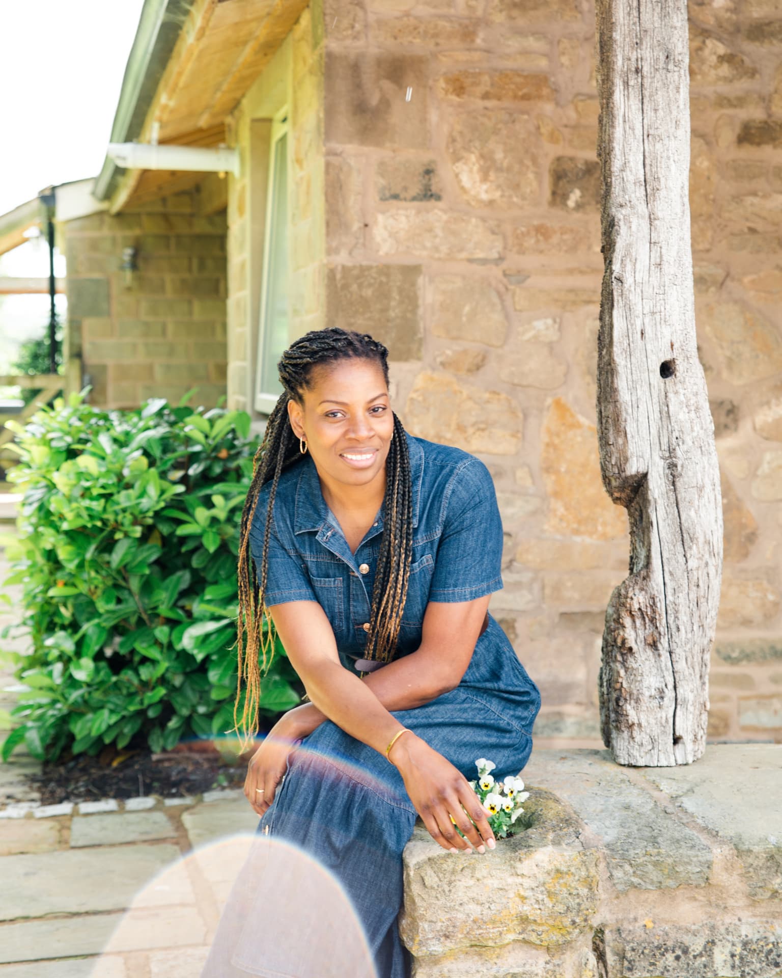Alison Eastick seated outdoors by a stone wall